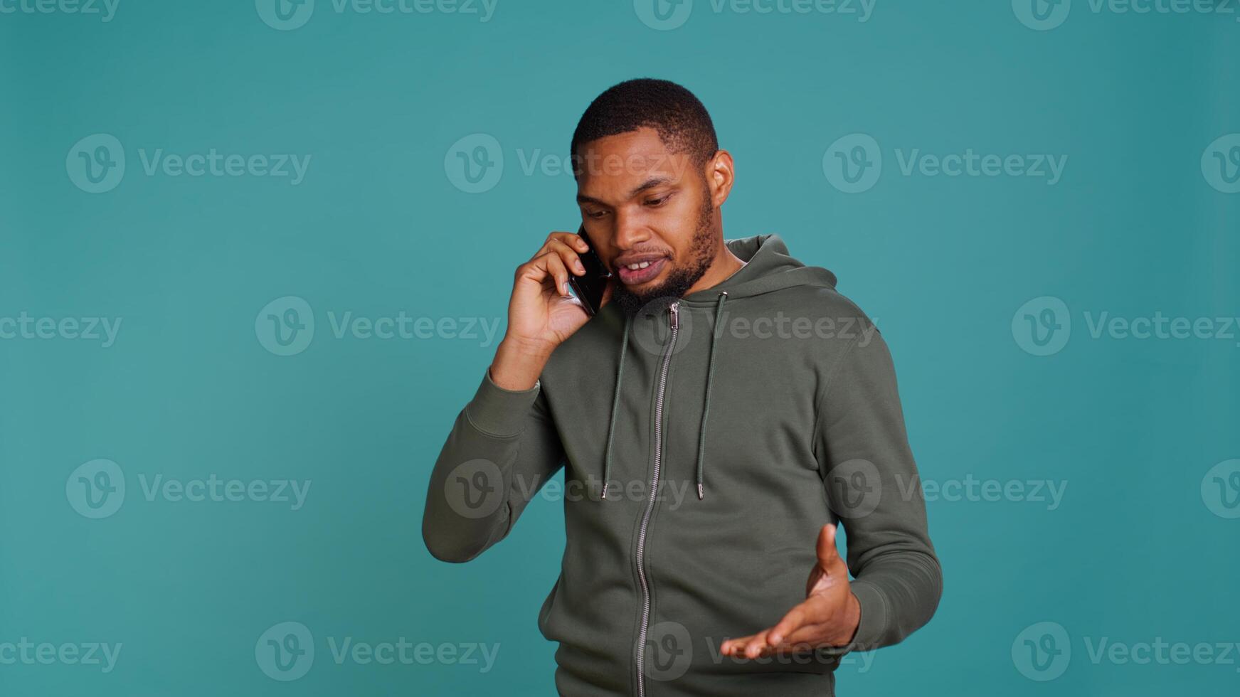 Irked african american man fighting with friends during telephone call, isolated over studio background. Outraged person arguing with mates during conversation on mobile phone, camera B photo