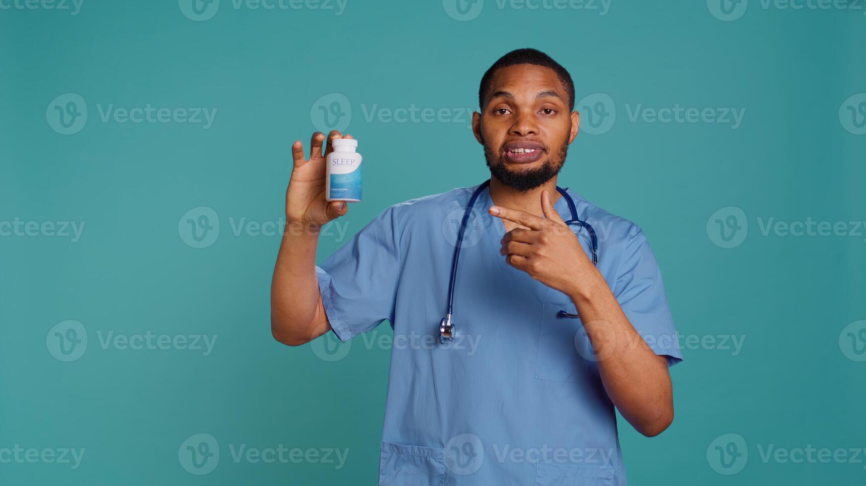 Portrait of hospital staff member holding sleep deprivation medicine for insomniacs, studio background. Doctor recommending pill bottle for patients with sleep disorder, camera B photo