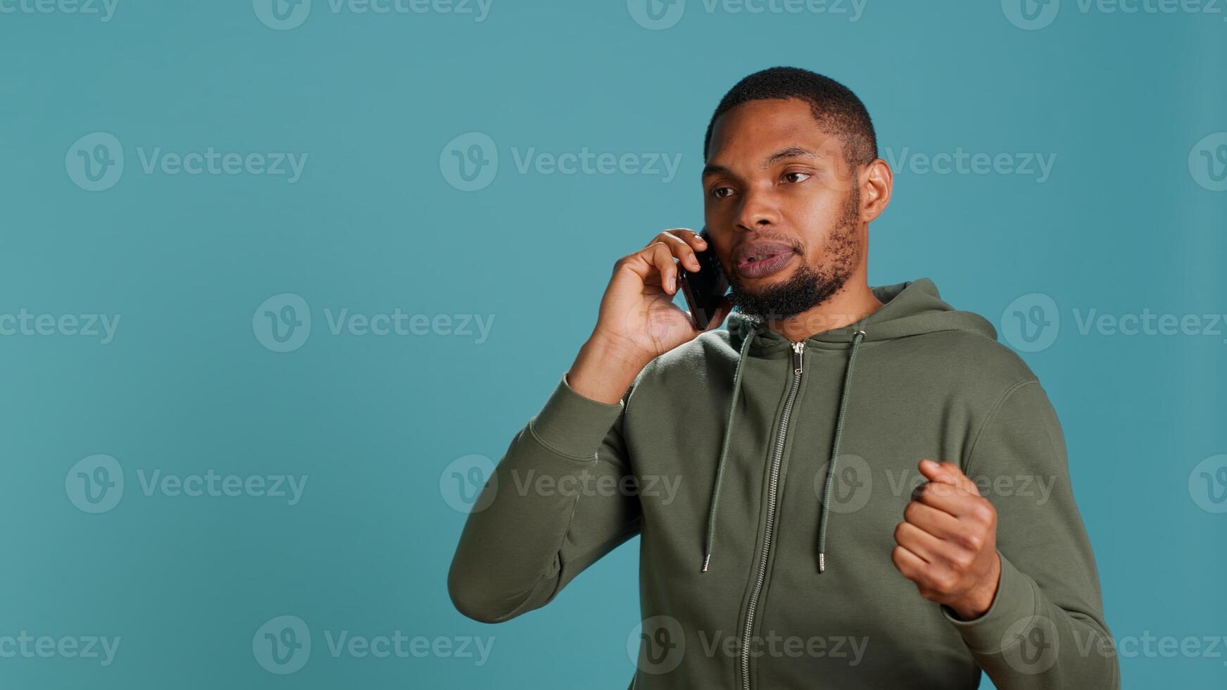 Irked african american man fighting with friends during telephone call, isolated over studio background. Outraged person arguing with mates during conversation on mobile phone, camera A photo