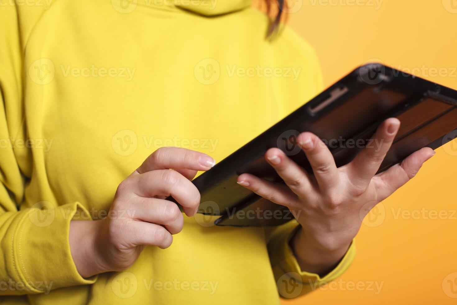 Close-up of female individual using digital tablet while surfing the internet. Caucasian person using a touch screen device while browsing a website on a gadget display. photo