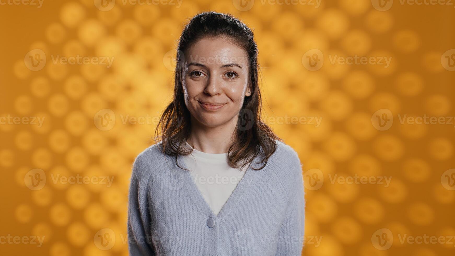 Cheerful woman happily doing salutation hand gesture, feeling optimistic. Portrait of joyous caucasian person raising arm to greet someone, gesturing, isolated over studio background, camera B photo