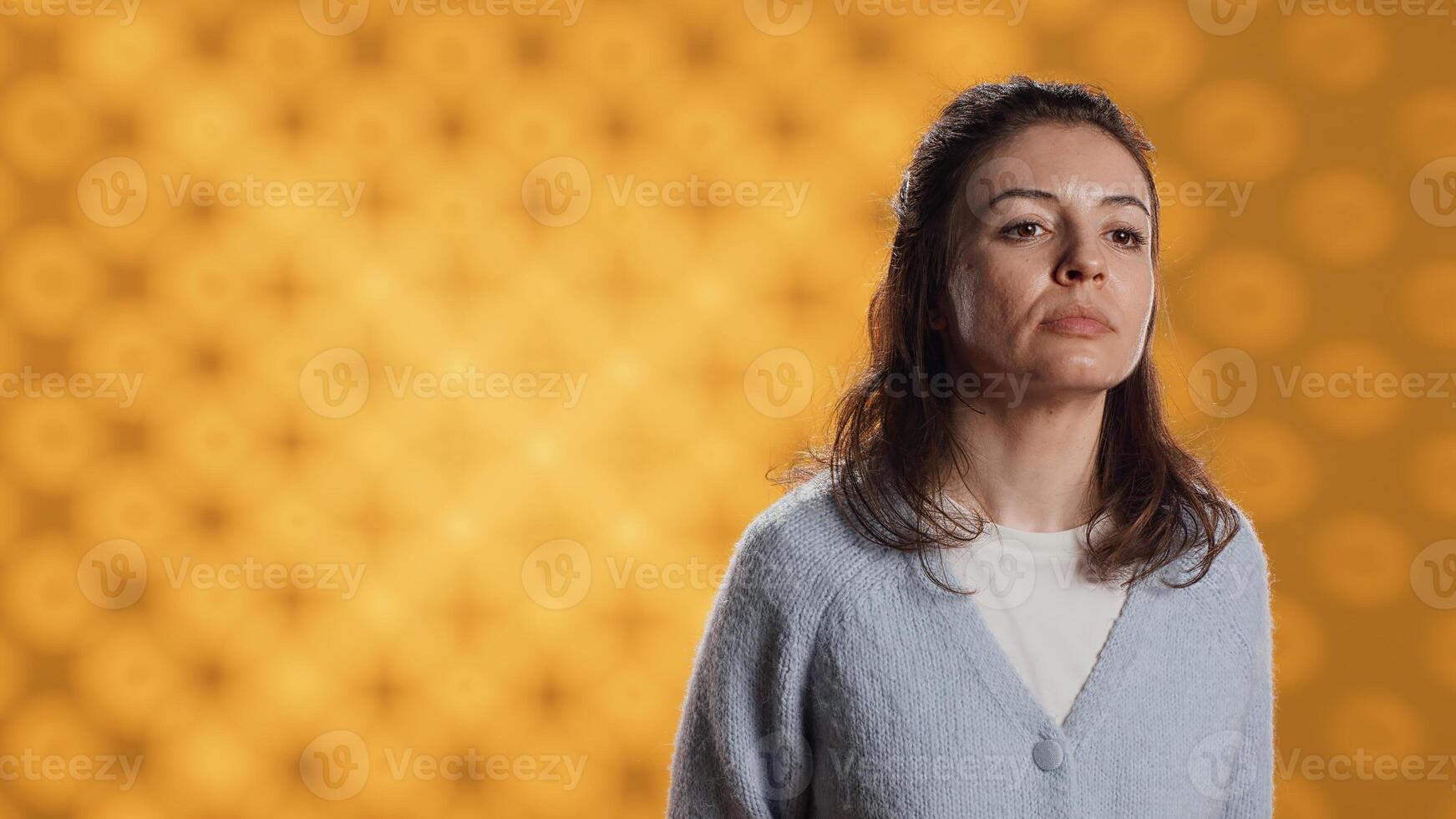 Portrait of upbeat optimistic woman posing, feeling happy and relaxed, isolated over yellow studio background. Close up shot of lively radiant caucasian lady standing, camera A photo