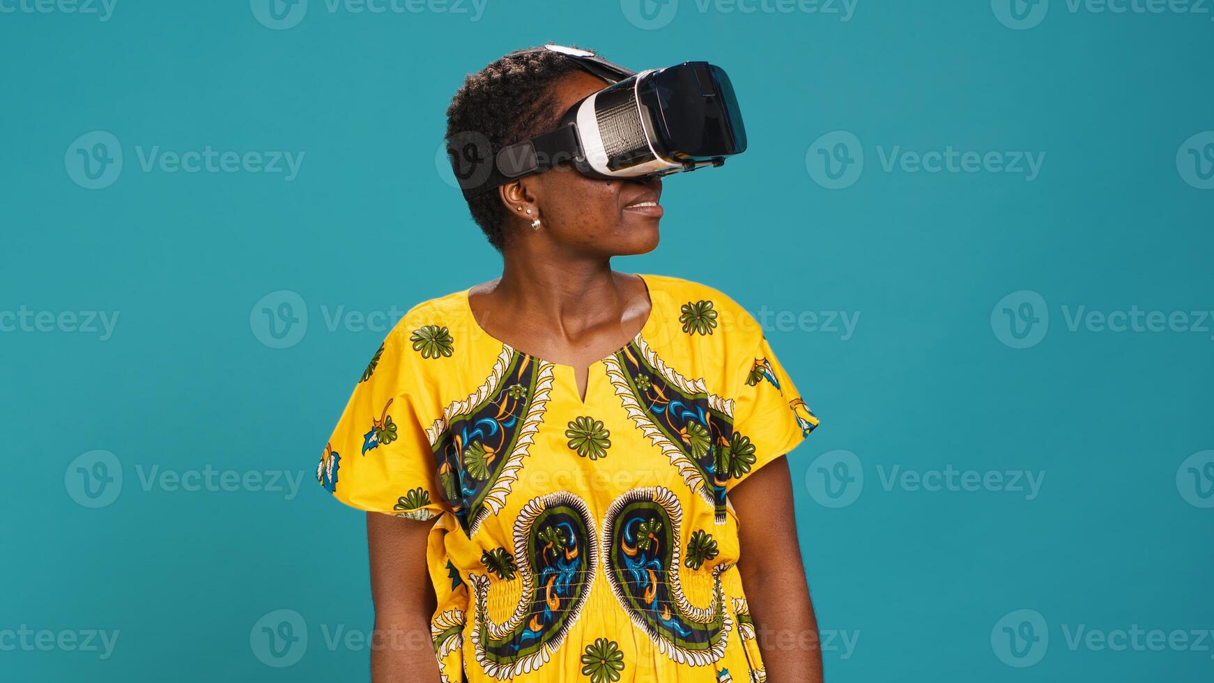 Young happy woman working with a virtual reality headset in studio, using the innovative 3d simulation experience with modern equipment. VR glasses on girl in traditional ethnic clothes. Camera A. photo