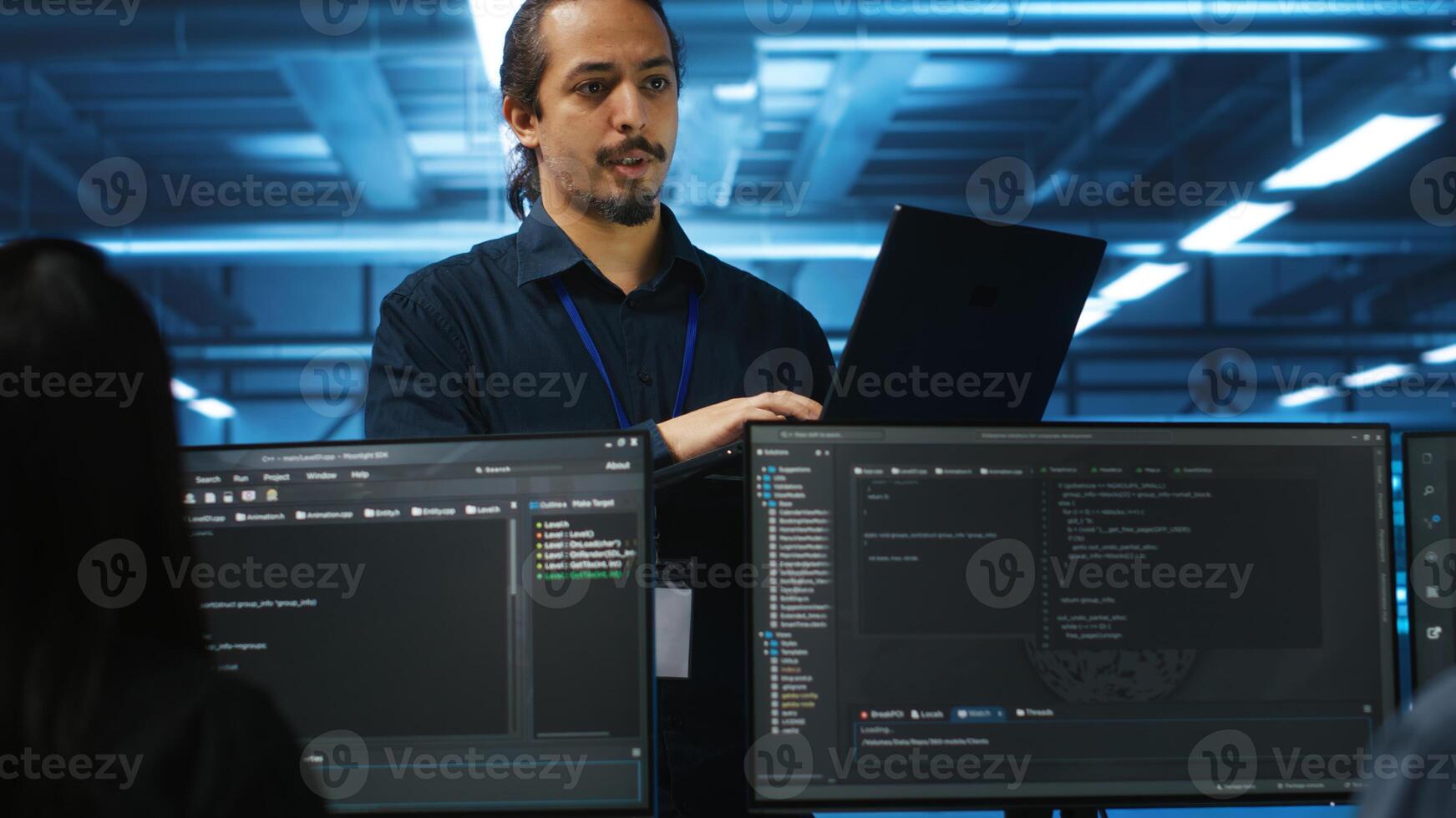 Manager in data center doing annual system review, checking parameters on laptop. Supervisor overseeing server clusters housing developed storage infrastructure used for workloads photo