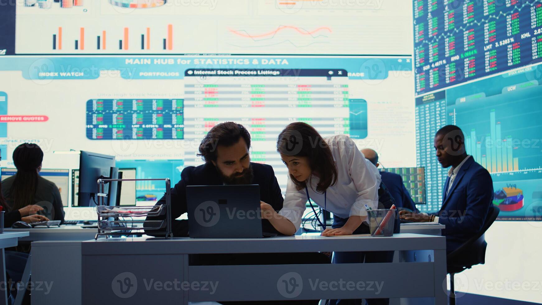 Business associate presents daily tasks order to enterprise administrator, discussing about funding and resources allocation in order to expand globally. Company analysts collaborate. Camera B. photo