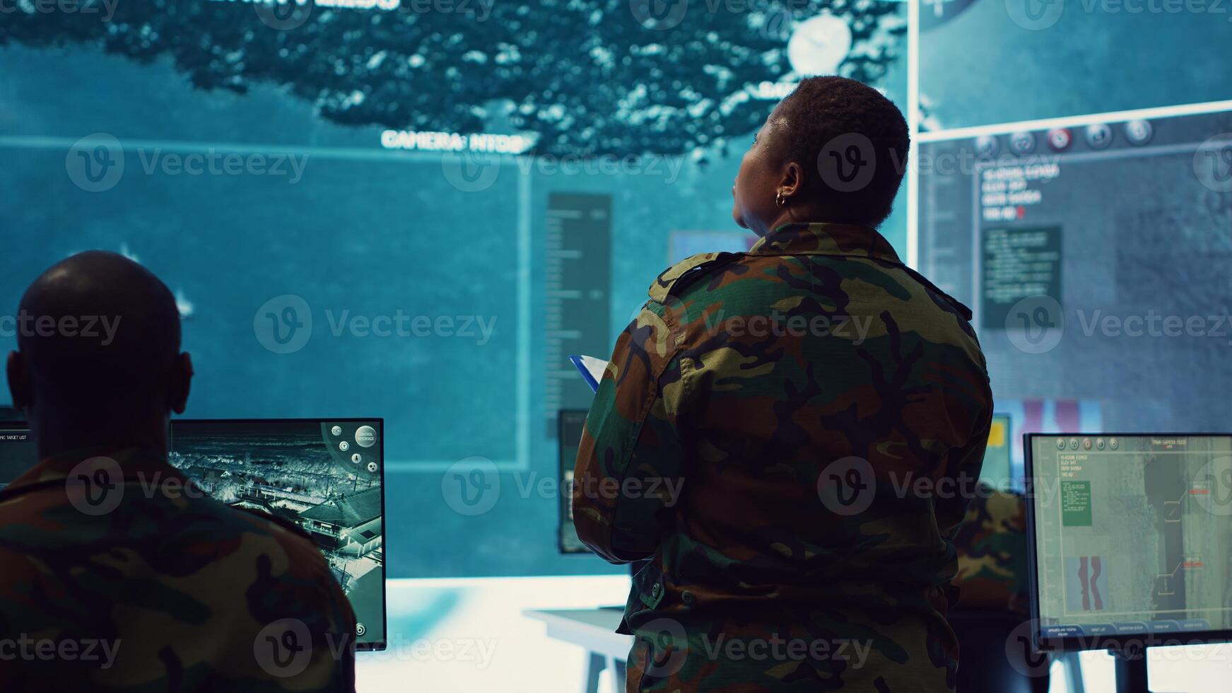 Woman colonel handling a special operation with big data in monitoring room, providing important satellite information to her crew in command post. Targeting enemy power base. Camera A. photo
