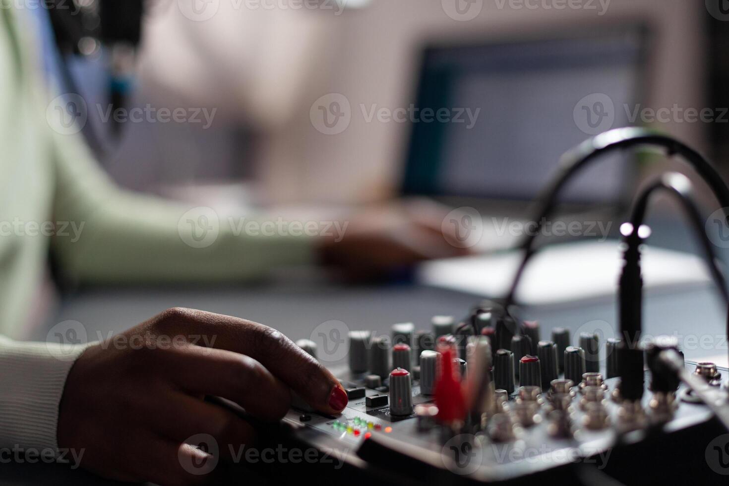 Closeup of influencer woman checking sound of professional mixer while recording online vlog talking with subscribers using microphone. Content creator filming for social media. On air talk show photo