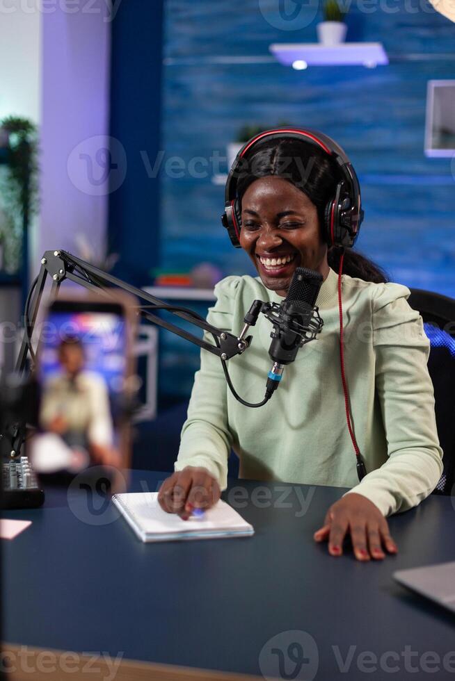 Social media creator woman smiling while recording content using modern smartphone for social media podcast. Vlogger influencer person talking with youtube answering subscribers questions photo