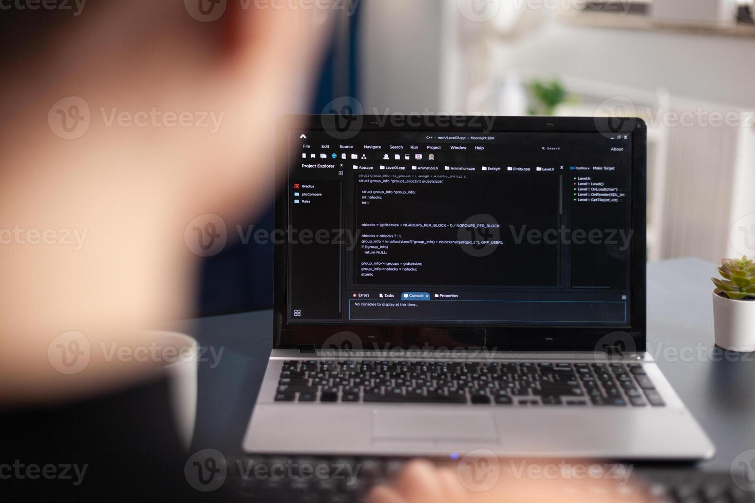 Freelancer writing code on laptop using keyboard. Freelance student programmer working remote developing software. Software coder looking for errors in home office. Code tester debugging. photo