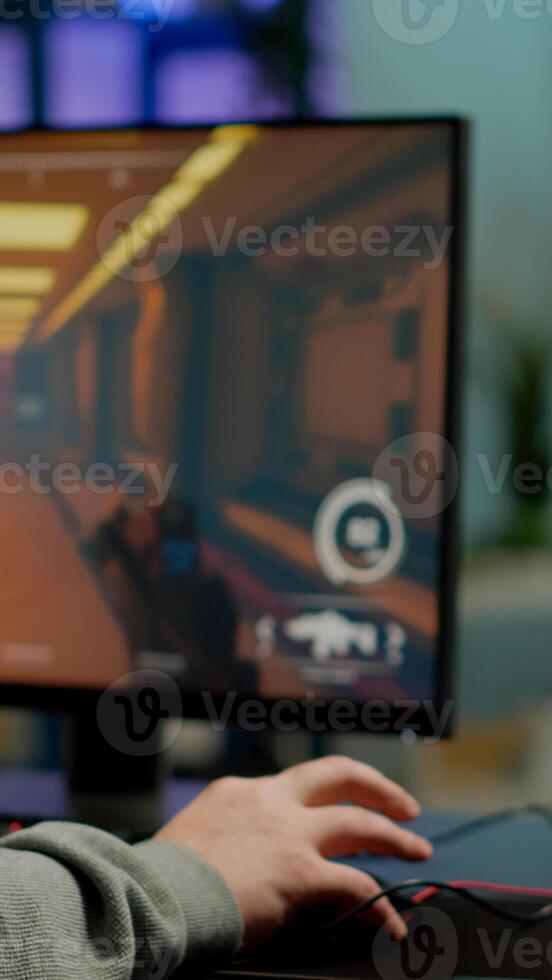 Close up of RGB powerful computer gamer rig with first-person shooter game on screen, pro cyber man participating at online esports championship. Player performing at gaming tournament in cyberspace photo
