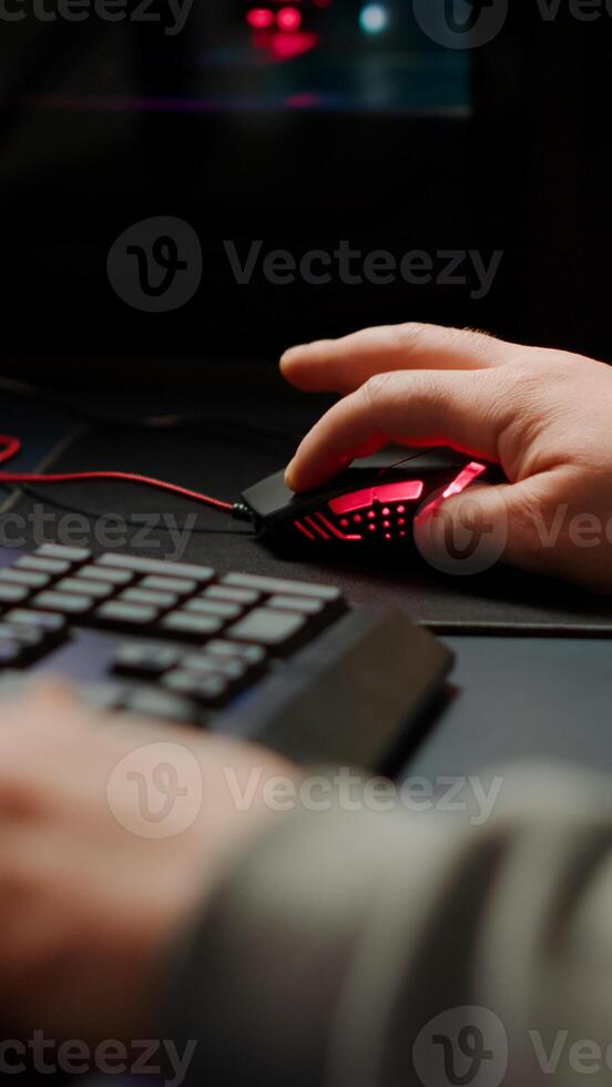 Close up hands shot of man player typing on RGB keyboard buttons while playing online shooter game. Virtual shooter game performing in cyberspace, esports gamer esports online tournament photo