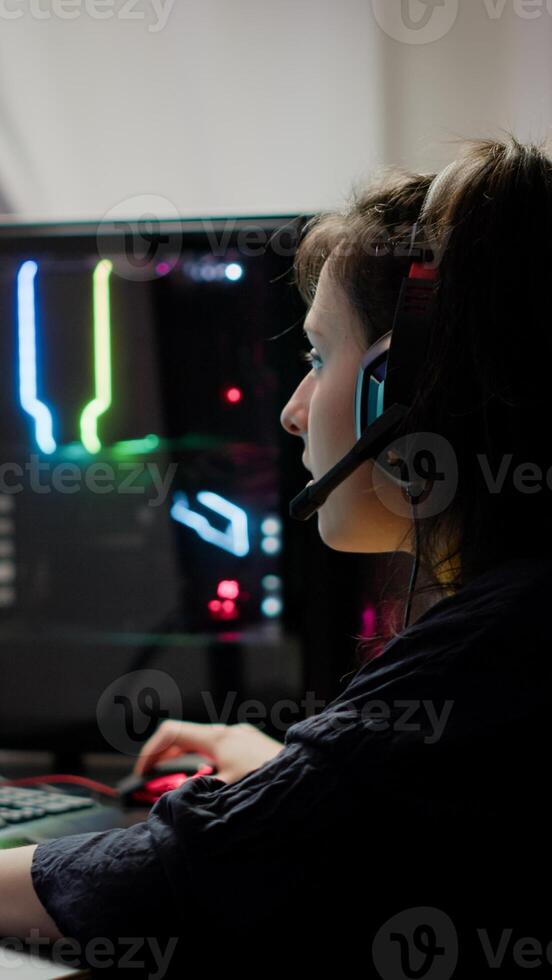 Pro woman game r using headset and powerful computer playing online space shooter games in gaming room. Virtual streaming cyber wearing headphones performing online tournament photo