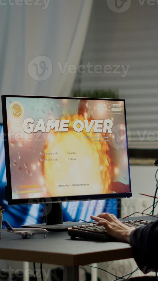 Furious pro woman gamer with headset losing space shooter game with new graphics during gaming championship playing from home at RGB powerful personal computer, performing at esports tournament photo