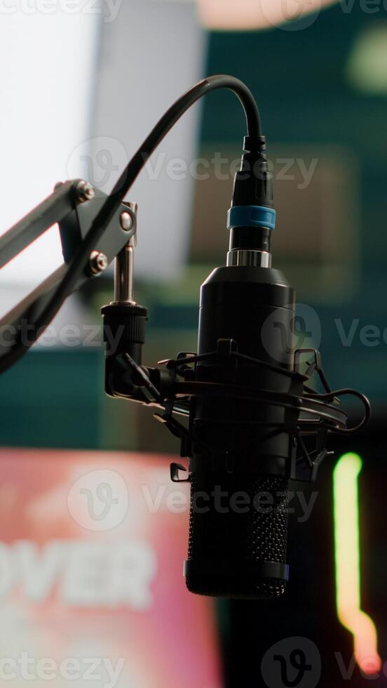 Streaming professsional microphone in empty gaming home studio with neon lights. Game is over on display of RGB professional powerful computer and stream chat is prepared for virtual tournament photo