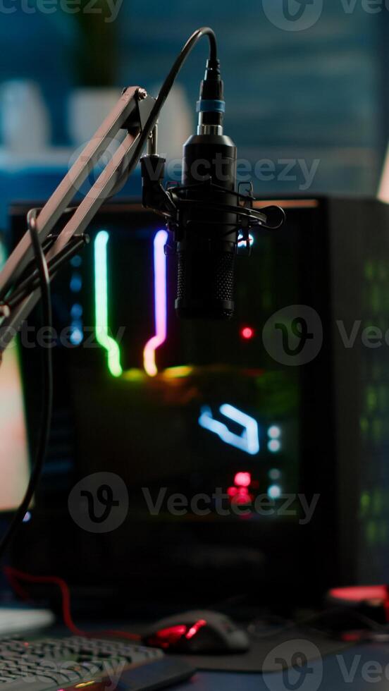 Game is over on display of RGB professional powerful computer and stream chat is prepared for virtual tournament. Streaming professsional microphone in empty gaming home studio with neon lights. photo