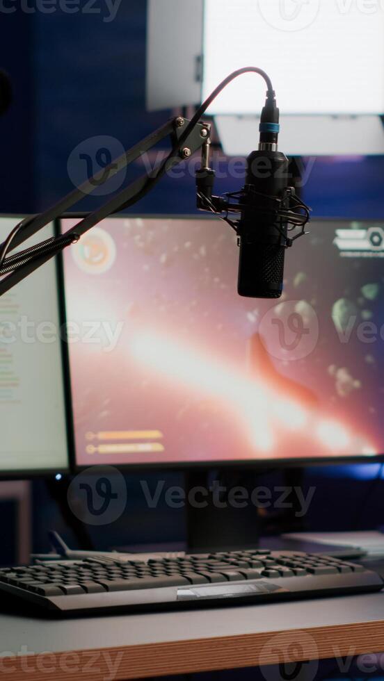 Empty streaming home studio equipped with professional equipment during online tournament late at night in gaming studio. Pro streamer playing space shooter game having esport championship photo