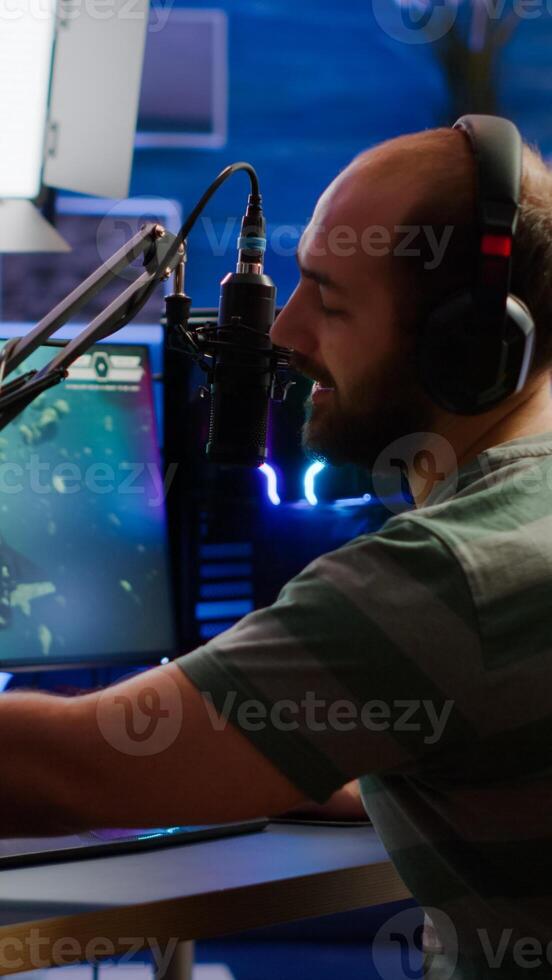 Man streamer cyber checking sound at mixer performing space shooter game on RGB powerful computer talking with players on stream chat and microphone in gaming competition. Player man streaming photo
