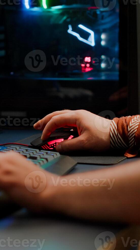 Close up of player hands using RGB keyboard in gaming home studio streaming space shooter game. Digital gamer using professional equipment for game competition late at night in living room photo