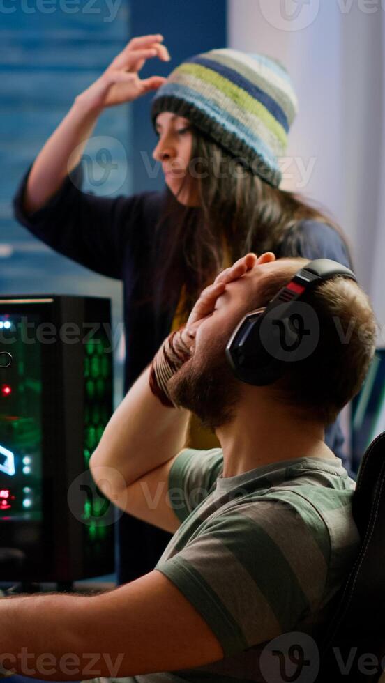 Nervous players couple losing online videogames competition using powerful computer screaming at each other. Streamer gamer playing games with RGB keyboard performing at gaming turnament photo