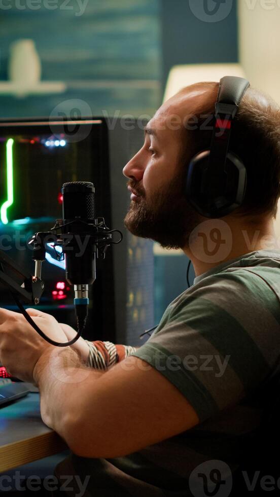 Pro cyber streamer losing videogame tournament while wearing professional headset holding wireless controller. Defeated gamer using joystick for online competition late at night in gaming room photo