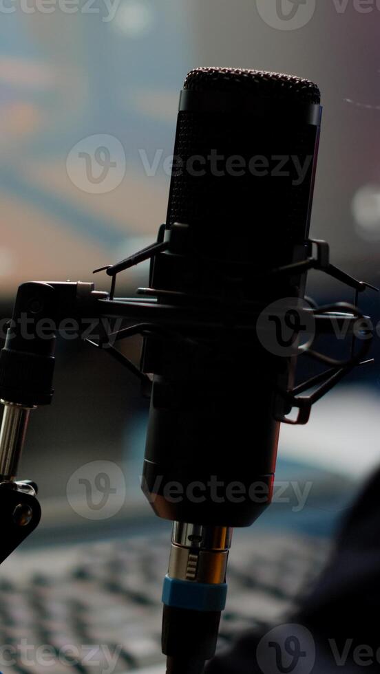 Close-up of pro streamer woman talking at microphone during virual games tournament. Cyber gamer streaming playing online games using RGB keyboard mouse late at night in gaming studio photo