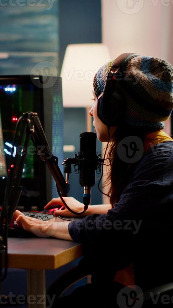 Woman streamer checking sound using professional mixer for streaming games in gaming home studio. Pro gamer playing first person shooter games talking with team mates on open chat photo