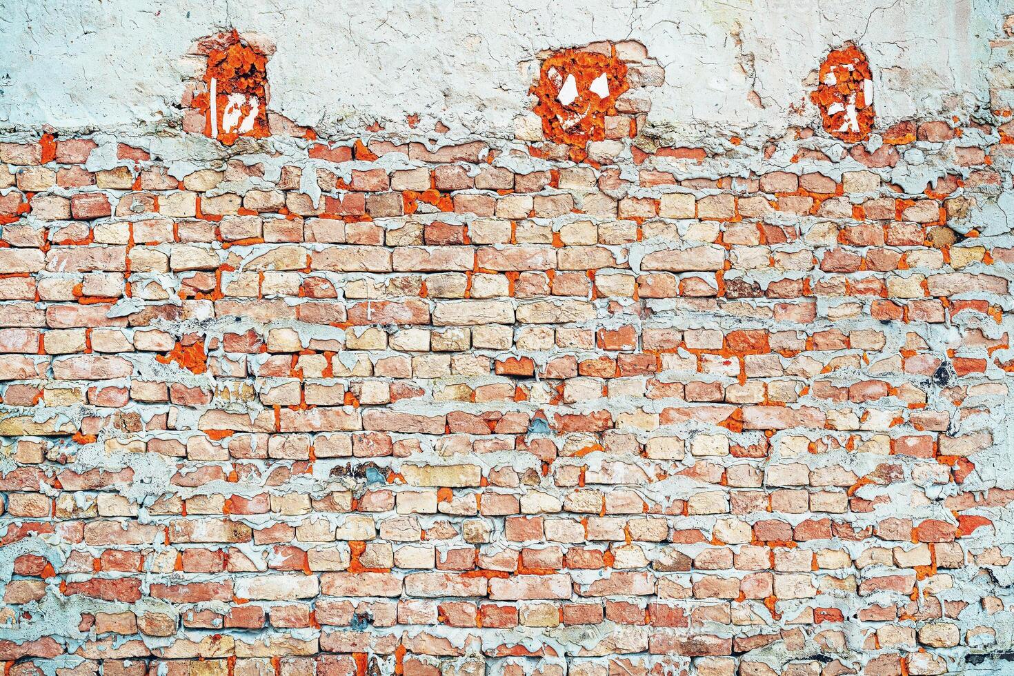 Texture of rough worn brick wall. Old facade as background. Urban patterns and details. photo