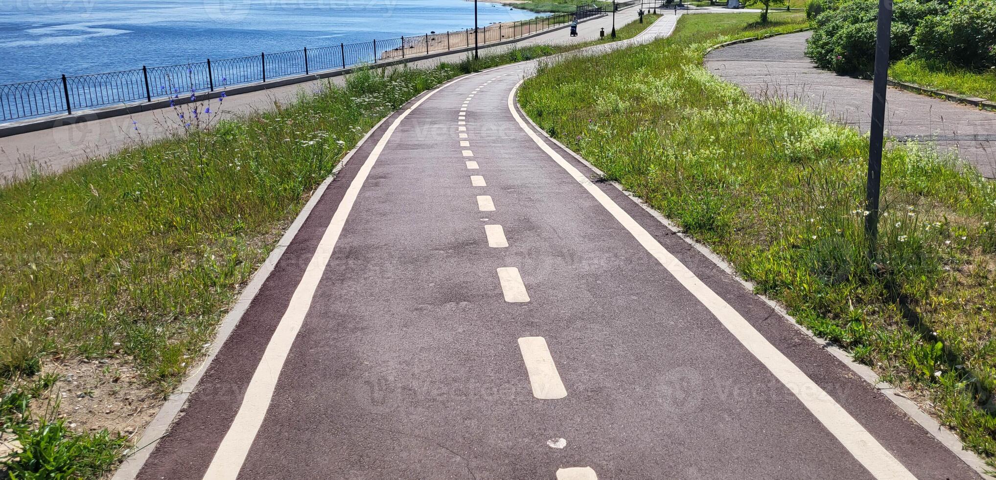 A red synthetic treadmill or bicycle path with white markings, with a turn. photo