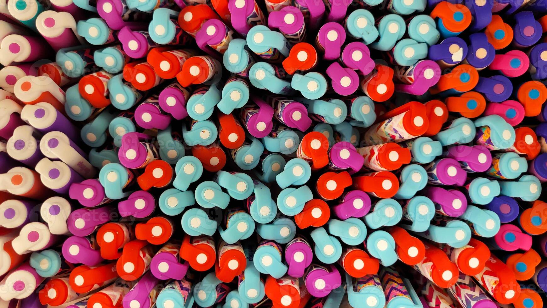 Abstract background of multicolored caps of plastic pens. A set of several liners, markers and colored markers of different colors, top view photo