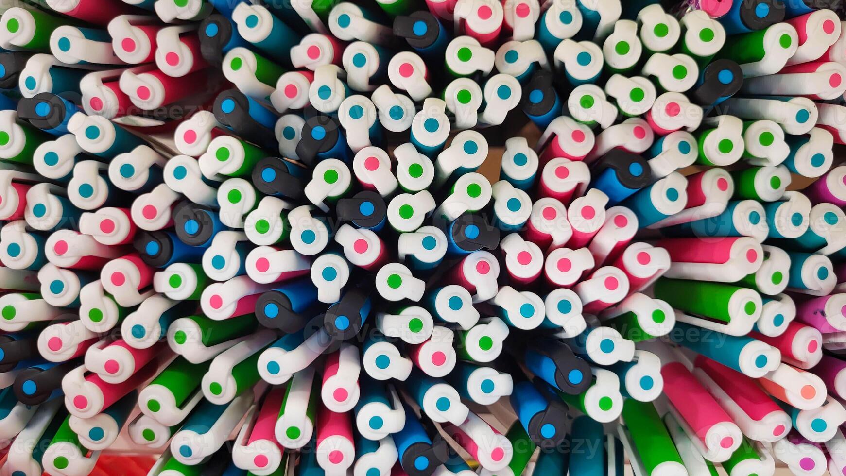 Abstract background of multicolored caps of plastic pens. A set of several liners, markers and colored markers of different colors, top view photo