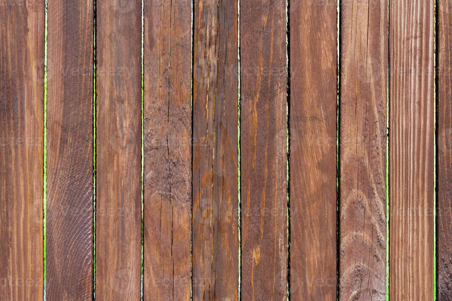 Aged cracked brown wooden planks of fence as background, texture photo