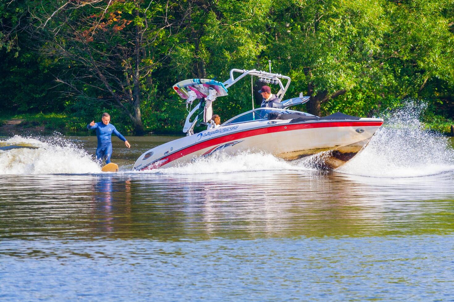 Russia, Moscow, september 2017 Man wakeboarding on a river behind the boat photo