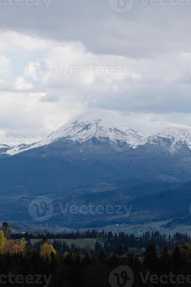 Snowy mountain range under cloudy sky photo
