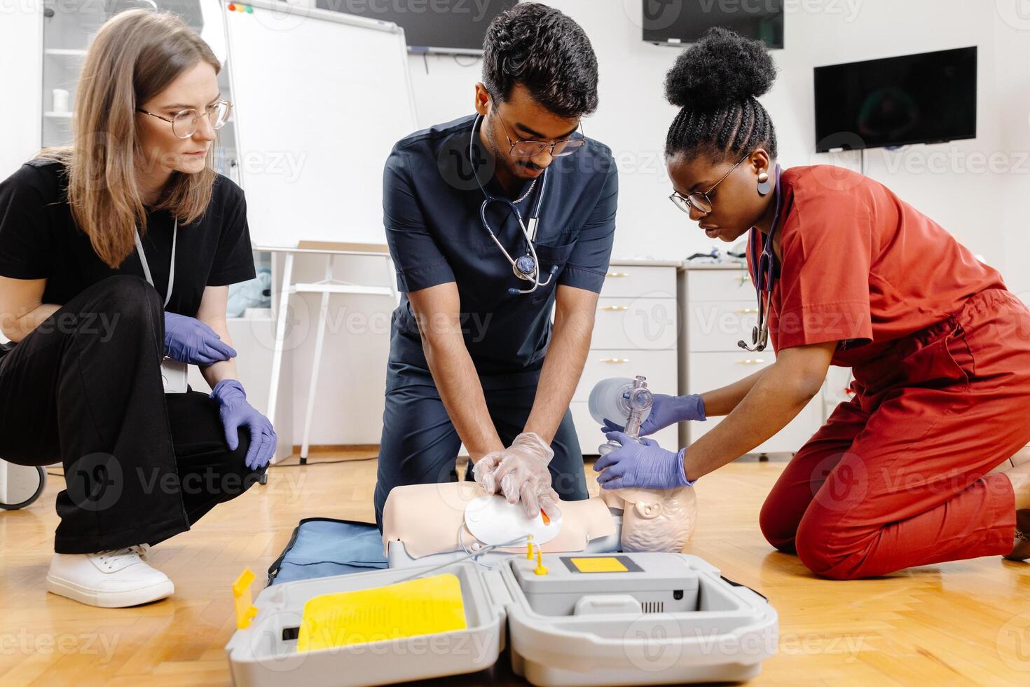 Three medical professionals are practicing CPR on a training dummy, demonstrating proper techniques and procedures photo
