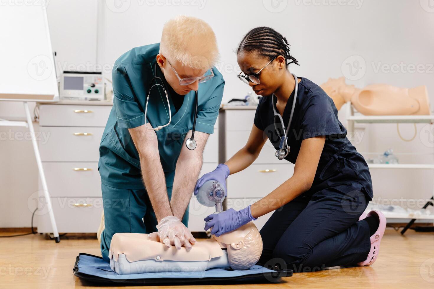Two medical professionals practice CPR on a training mannequin, demonstrating proper technique and teamwork photo
