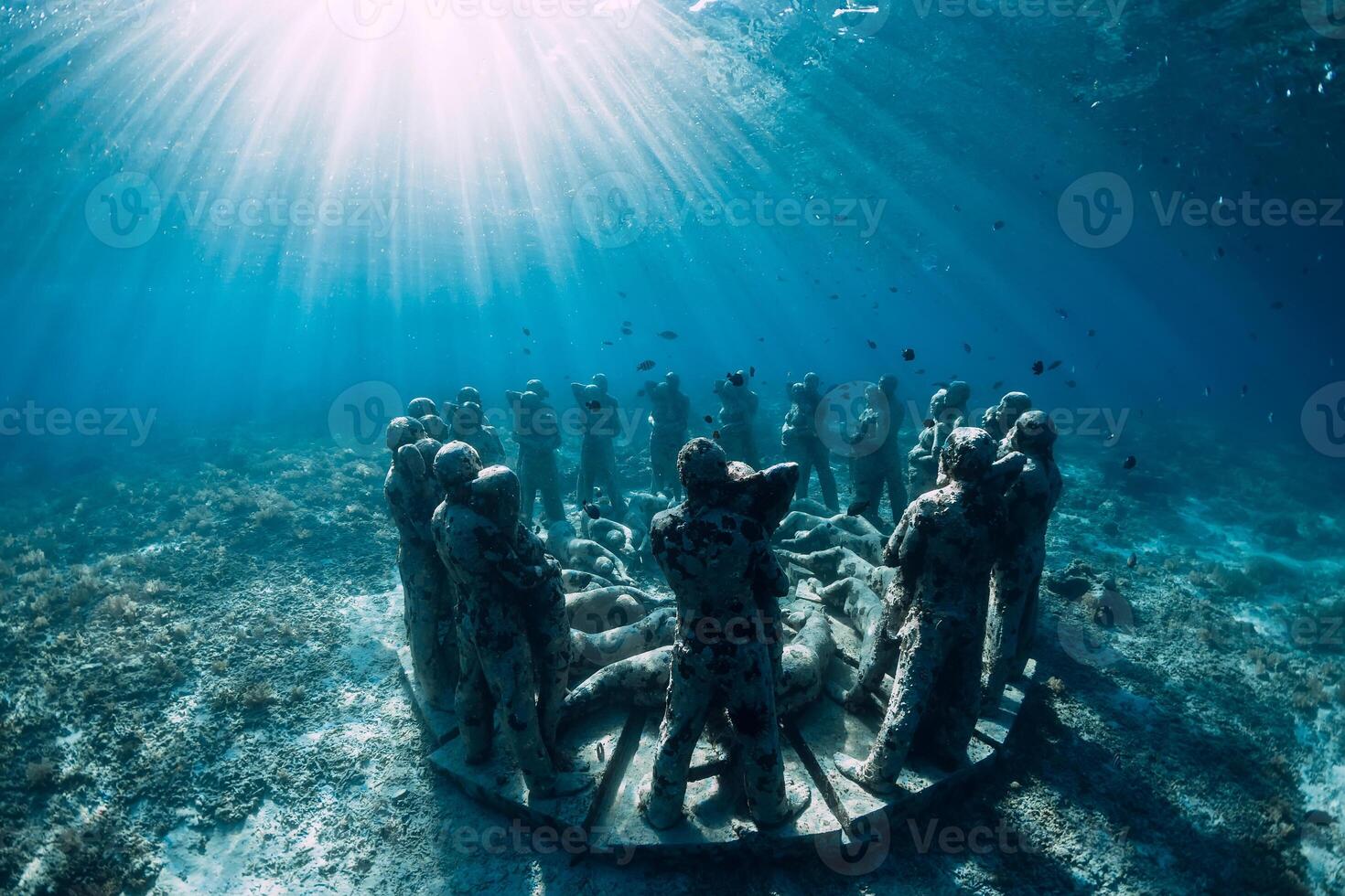 Underwater statues in blue ocean with fish. Underwater tourism in ocean. photo