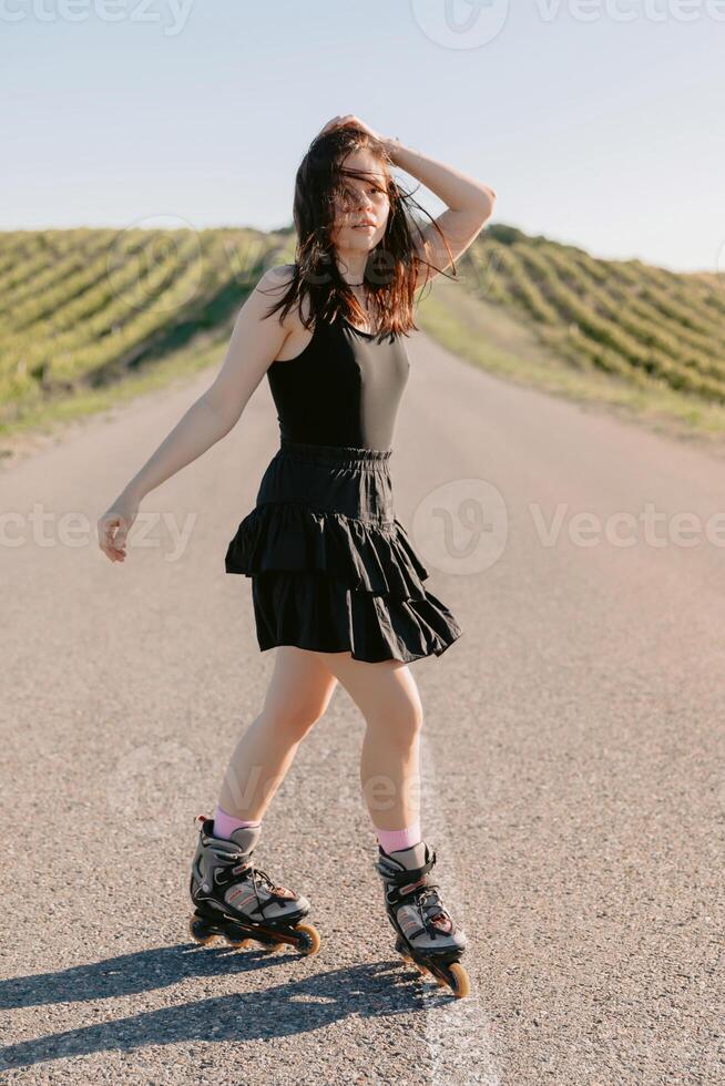 Young woman ride on roller skates outdoor on sunny day photo