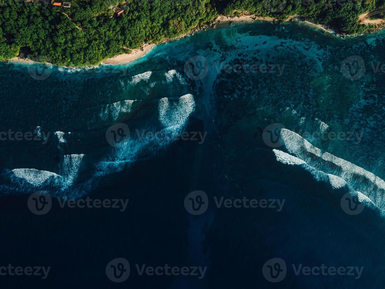 Aerial view of coastline with ocean waves and current canal in Bali. Green bowl beach photo