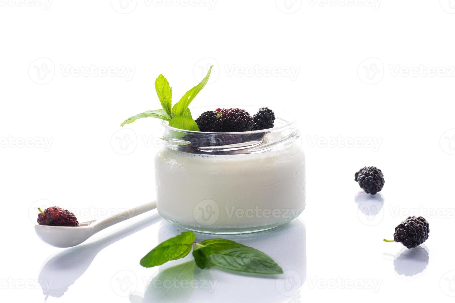 homemade sweet yogurt in a jar with black mulberries isolated on white background photo