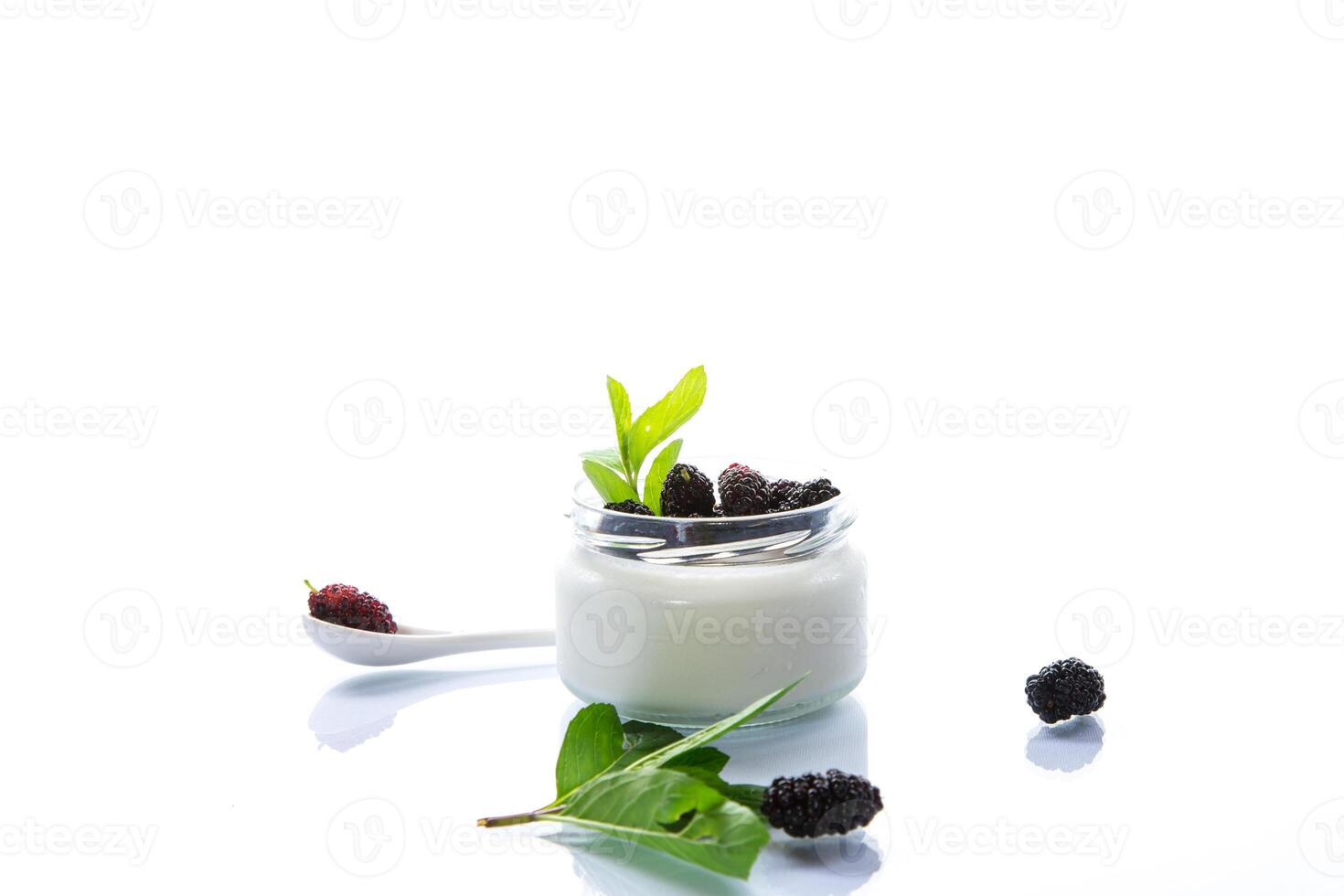 homemade sweet yogurt in a jar with black mulberries isolated on white background photo
