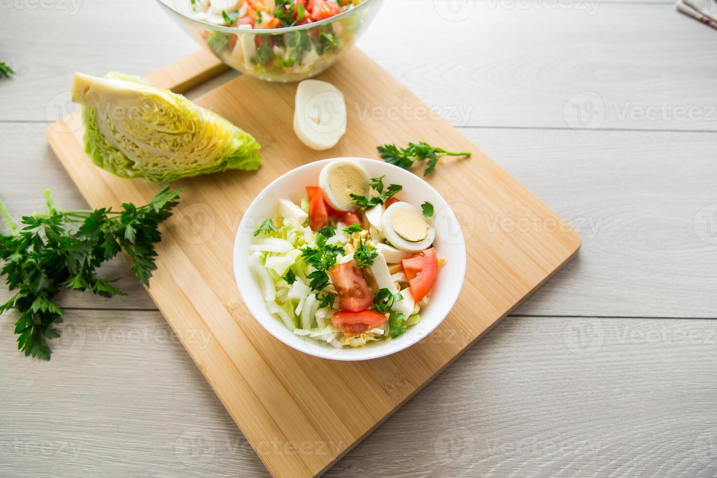fresh vegetable salad, cabbage, tomatoes in a bowl on a wooden table photo