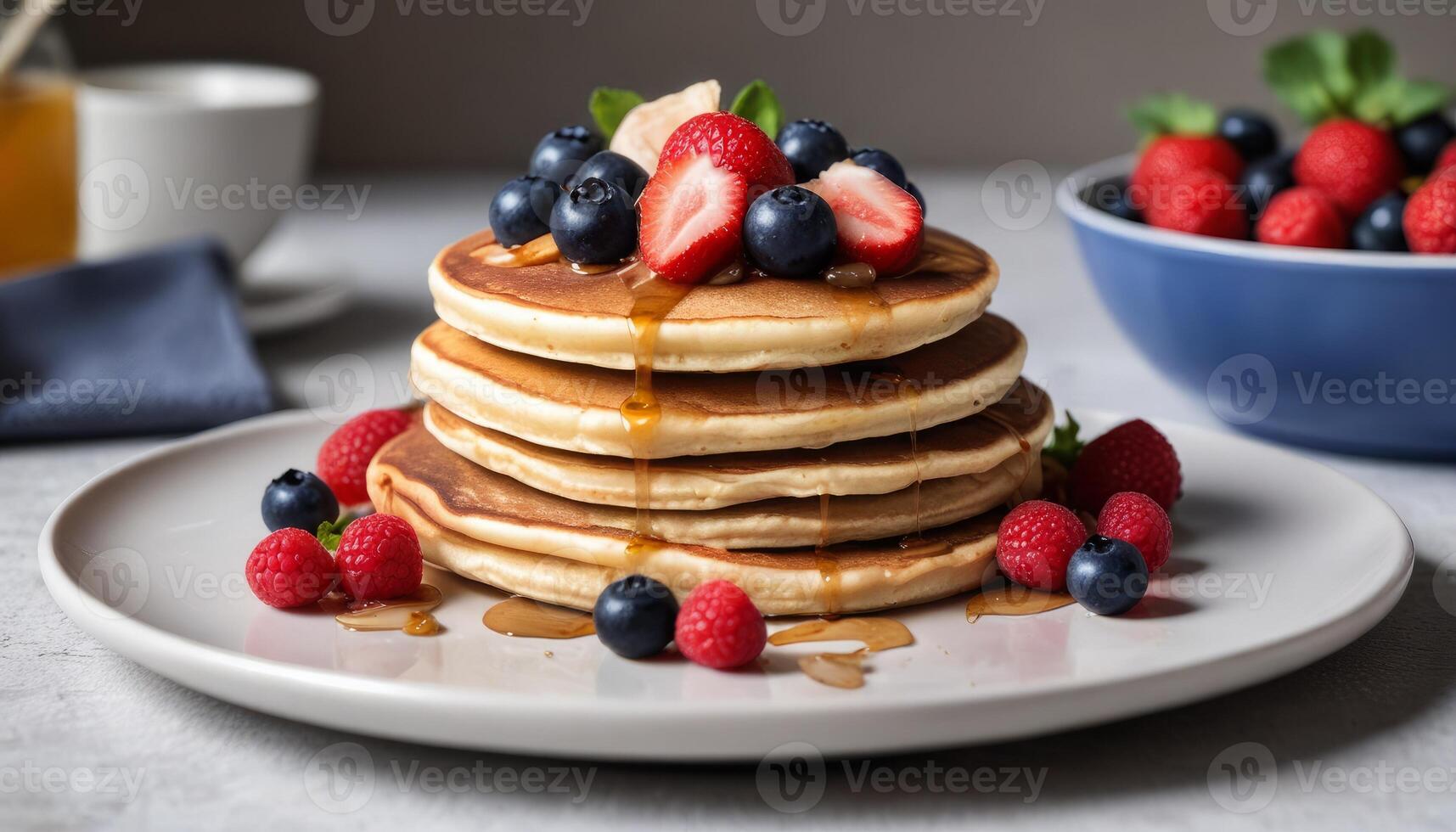 A stack of pancakes with blueberries and strawberries on top photo