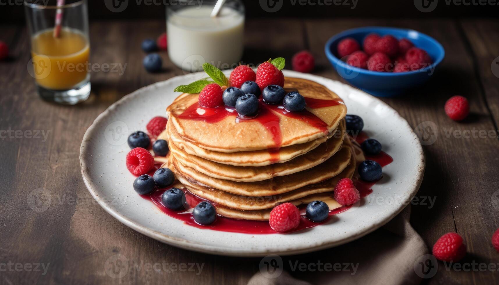 A stack of pancakes with blueberries and raspberries on top photo