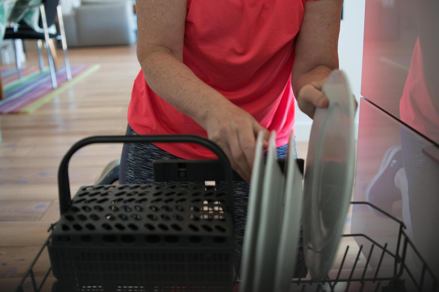Unrecognizable woman arranging the dish washer photo