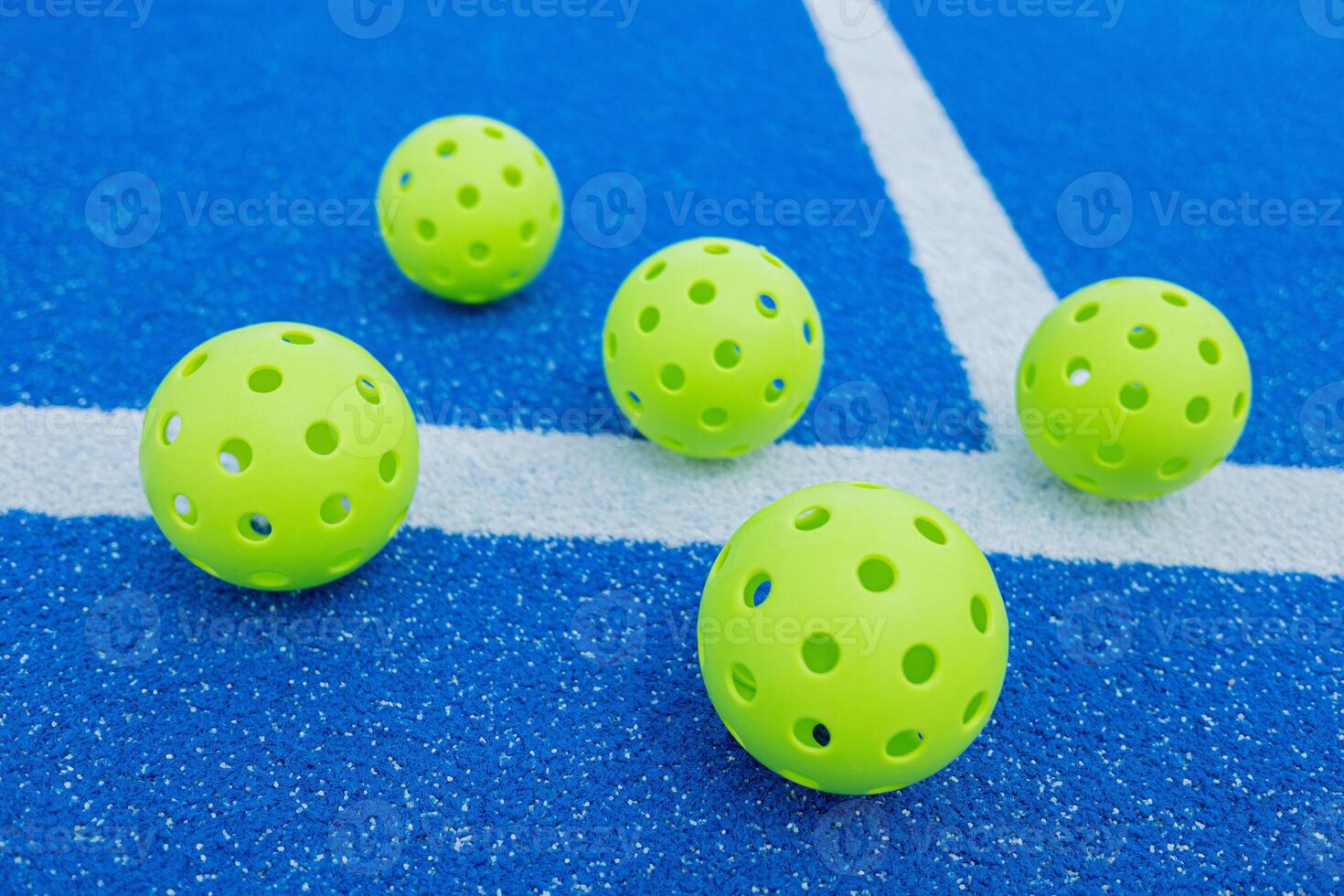 five green pickleball balls in a pickleball court, new racket sport photo