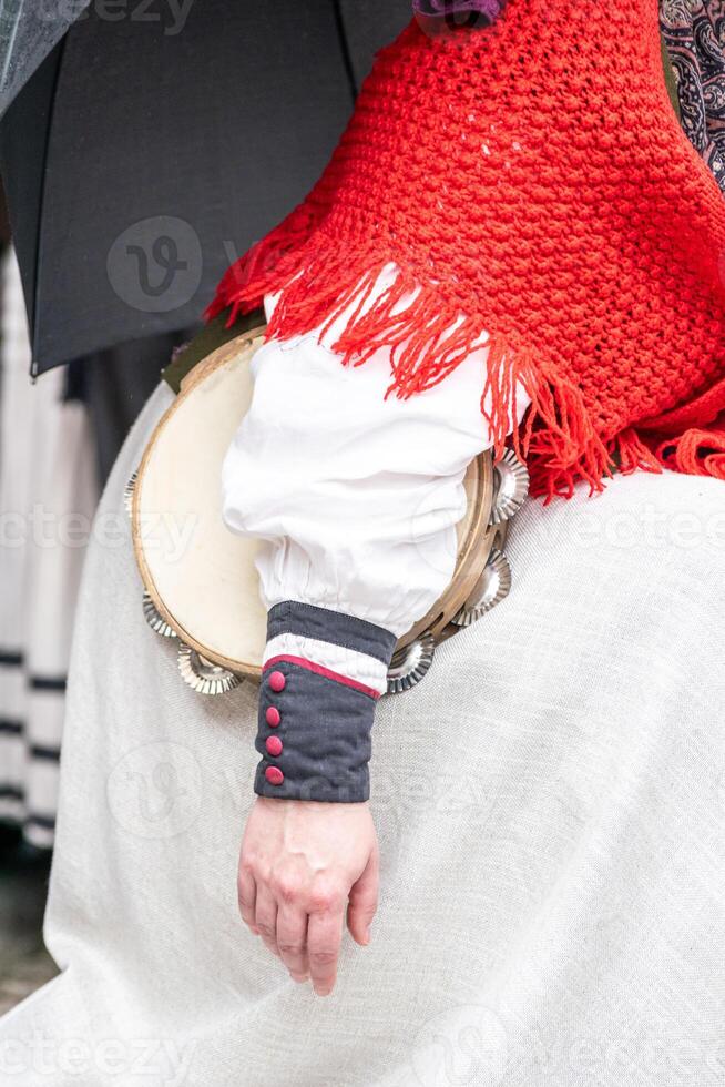 detail of a woman dressed in the traditional costume of Galicia, holding a tambourine under her arm photo