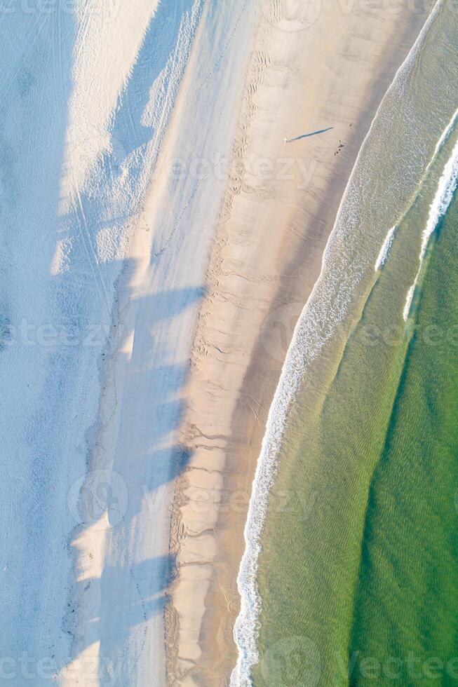 shore of a beach at sunrise in summer as seen from a drone, directly above image photo