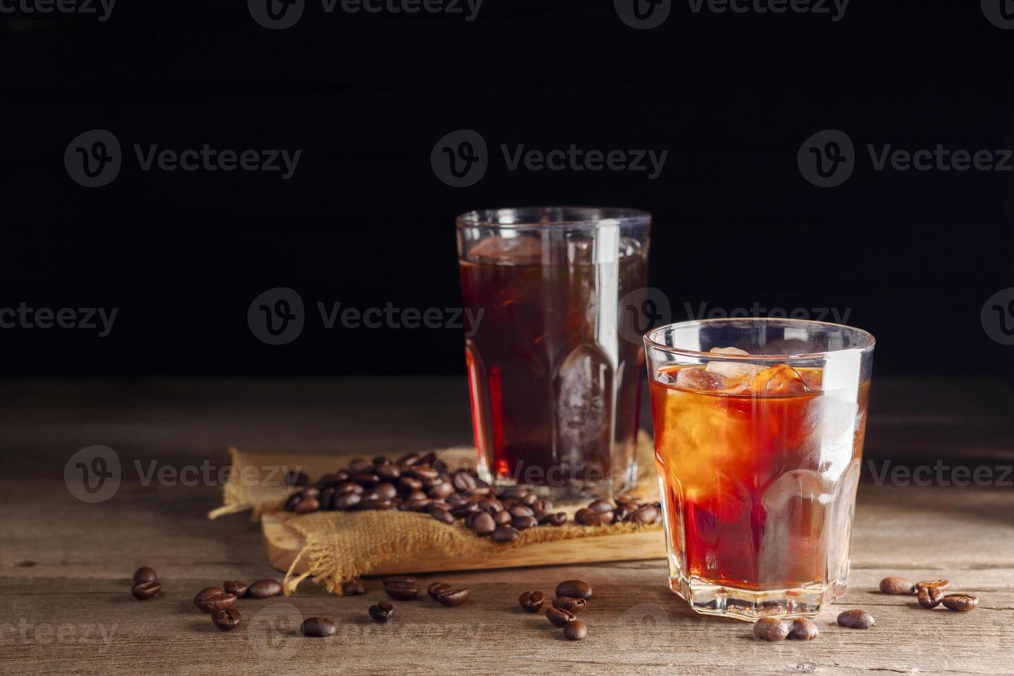 Soft iced coffee with milk, cream, white foam and ice. Coffee latte, espresso, cappuccino, cocktail ready to drink on dark and black background. photo