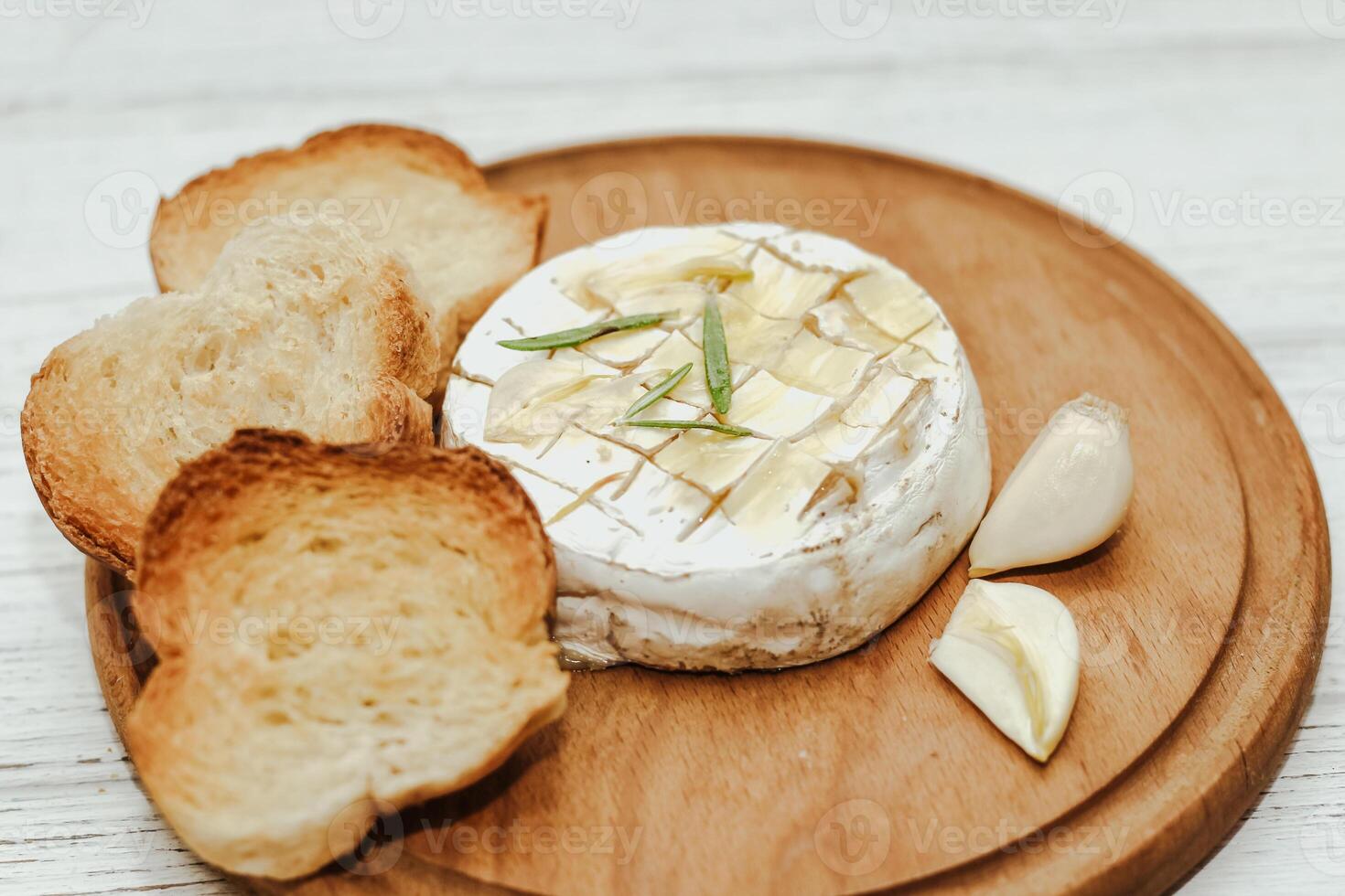 White baguette cut into pieces with olive oil and Camembert cheese on the table. photo