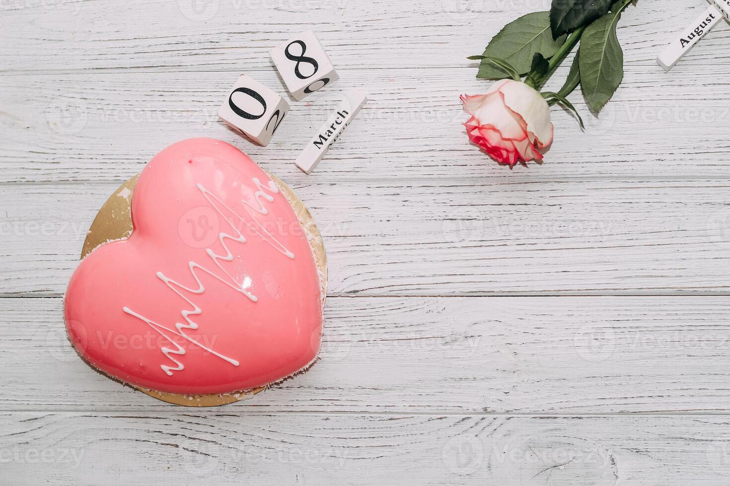 Pink tea rose with heart shaped pink mousse cake and February 14 calendar. photo